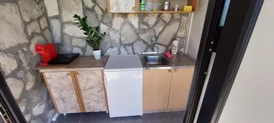 a small kitchen with a sink and a stone wall at Guest House Vodica in Virpazar