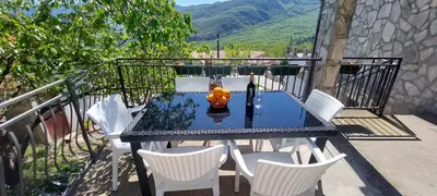 a table and chairs on a balcony with a fire hydrant at Guest House Vodica in Virpazar
