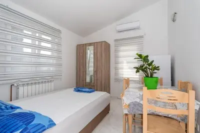 a bedroom with a bed and a table with a plant at Apartmani Murić Bar in Bar