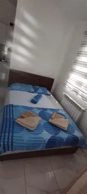a bedroom with a bed with two towels on it at Apartmani Murić Bar in Bar