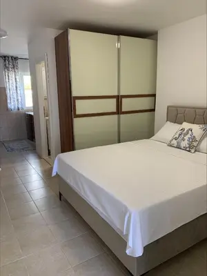 a bedroom with a large bed with white sheets at Popi in Budva