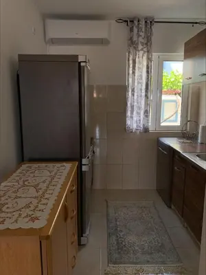 a small kitchen with a refrigerator and a window at Popi in Budva