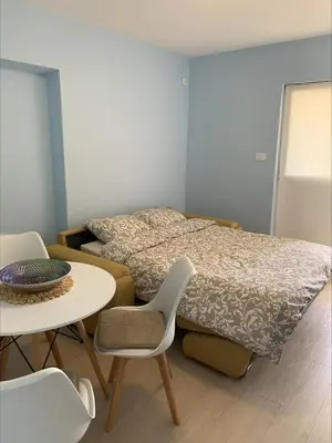 a bedroom with a bed and a table and chairs at Popi in Budva