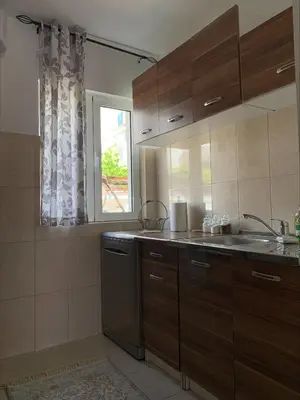 a kitchen with wooden cabinets and a sink and a window at Popi in Budva
