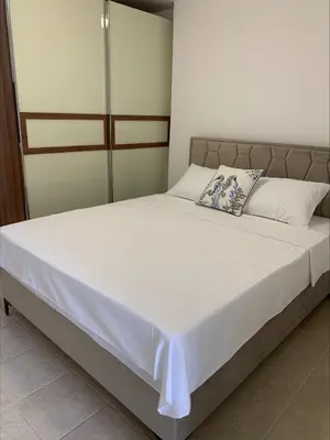 a bed with white sheets and pillows in a bedroom at Popi in Budva