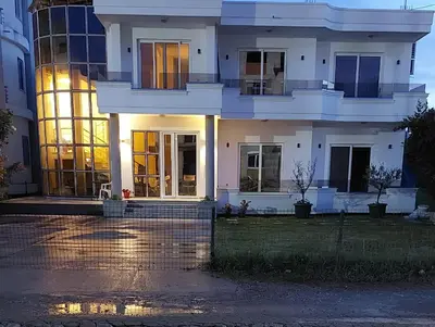 a large white house with its lights on at Rinia Apartments in Ulcinj
