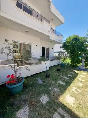 a house with potted plants in the yard at Rinia Apartments in Ulcinj