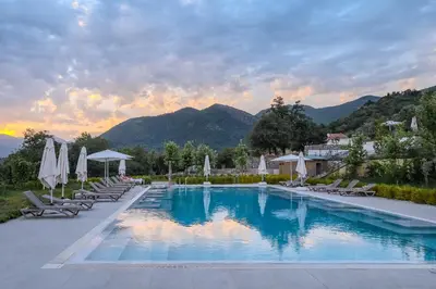 a large swimming pool with chairs and umbrellas at Montenegro Lodge in Tivat