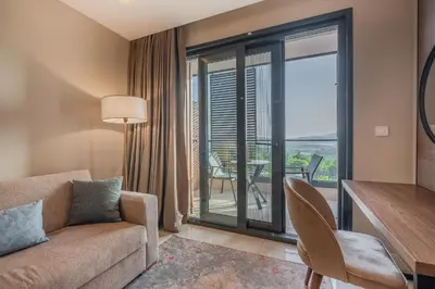 a living room with a couch and a table and a balcony at Montenegro Lodge in Tivat