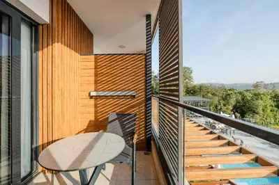 a balcony with a table and a glass railing at Montenegro Lodge in Tivat