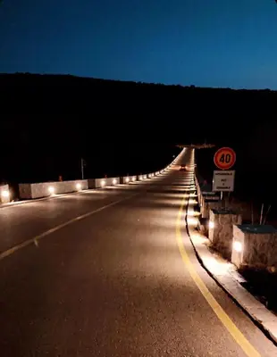 an empty road at night with a speed limit sign at Lazarus Bigova apartments in Tivat