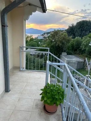 a balcony with a plant in a pot on a house at Lazarus Bigova apartments in Tivat