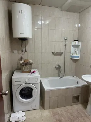 a bathroom with a washing machine and a bath tub at Bella Apartman in Podgorica