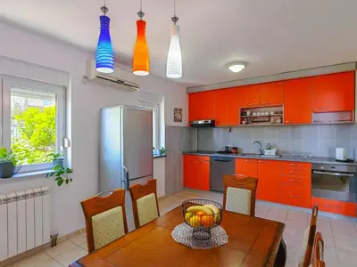 a kitchen with orange cabinets and a wooden table at The rising sun-Stylish Sea View Apartment in Budva