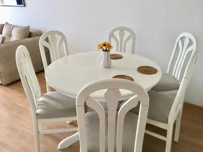 a white dining room table and chairs with a vase of flowers at Monika in Budva