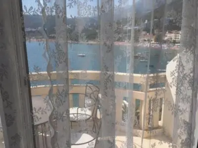 a window with a view of a building and the water at Monika in Budva