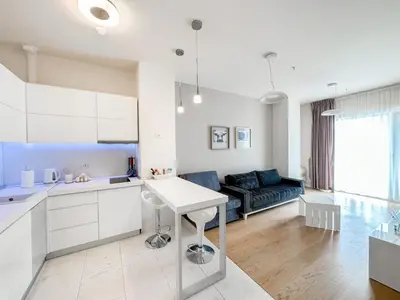a white kitchen and living room with a couch at Sea View Tre Canne Apartment in Budva