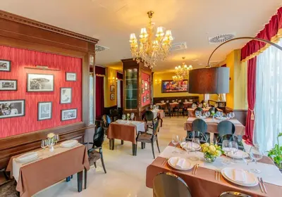 a restaurant with tables and chairs and a chandelier at Sea View Tre Canne Apartment in Budva