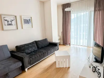 a living room with a black couch and a television at Sea View Tre Canne Apartment in Budva