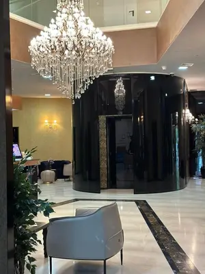 a large lobby with a chandelier and a chair at Sea View Tre Canne Apartment in Budva