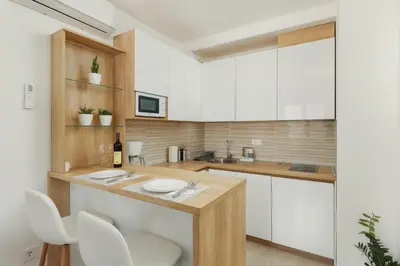 a kitchen with white cabinets and white counters at DM Apartments in Kotor