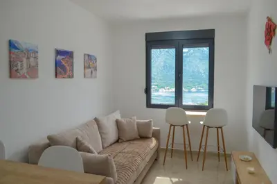 a living room with a couch and two stools at DM Apartments in Kotor