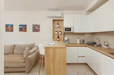 a kitchen and living room with a couch at DM Apartments in Kotor