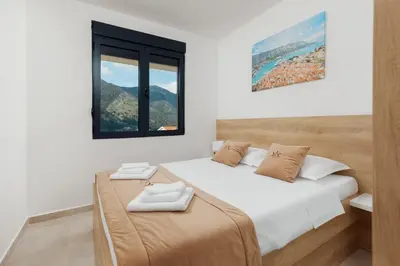 a bedroom with two beds and a window at DM Apartments in Kotor