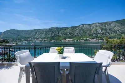 a table and chairs on a balcony with a view of the water at The Golden Luxury Apartments in Kotor