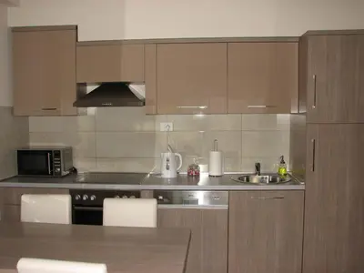 a kitchen with wooden cabinets and a sink at Apartment B&S in Budva