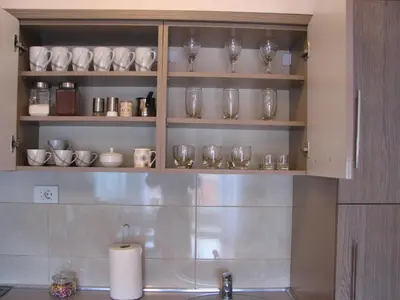 a kitchen with shelves filled with glasses and a sink at Apartment B&S in Budva