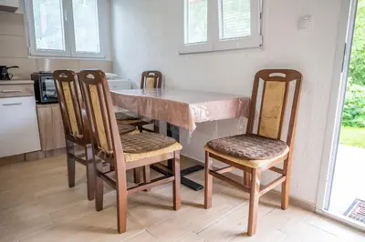 a kitchen with a table and four chairs at Vikendica Luka in Čanj