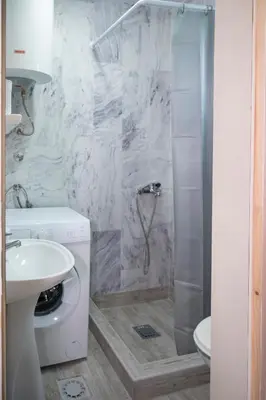 a bathroom with a shower and a toilet and a sink at Vikendica Luka in Čanj