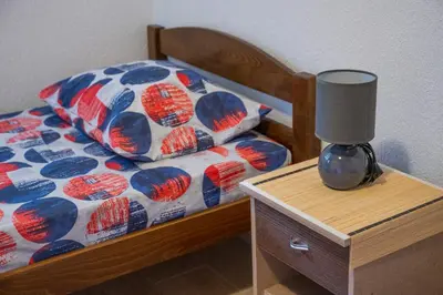 a bedroom with a bed with a lamp on a night stand at Vikendica Luka in Čanj