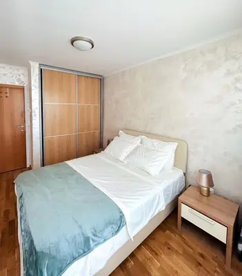 a bedroom with a large bed and a table at V Lux Apartment Sveti Stefan in Sveti Stefan