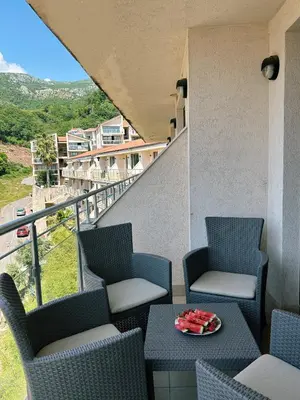 a balcony with chairs and a table with a view at V Lux Apartment Sveti Stefan in Sveti Stefan