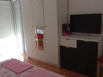 a room with a television and a table with a bed at ILIC APARTMENTS in Budva