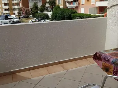 a balcony with a white wall and a table at ILIC APARTMENTS in Budva
