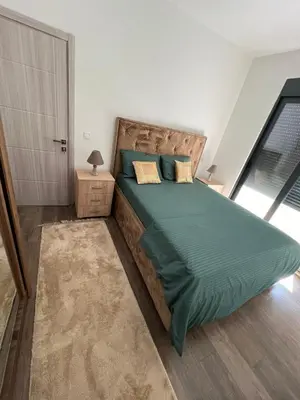 a bedroom with a large bed with a green comforter at Glamur Apartman - Ulcinj in Ulcinj