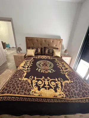 a large bed with a black and gold bedspread at Glamur Apartman - Ulcinj in Ulcinj