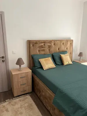 a bedroom with a bed with blue and yellow pillows at Glamur Apartman - Ulcinj in Ulcinj
