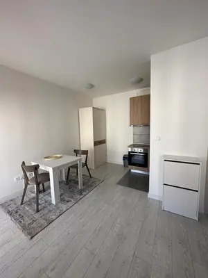 a living room with a table and chairs and a kitchen at Eastside studio in Podgorica