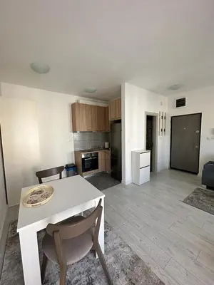 a kitchen and living room with a white table and chairs at Eastside studio in Podgorica