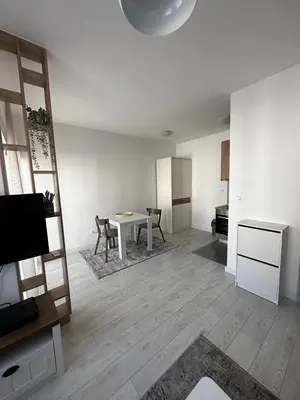 a living room with a table and a kitchen at Eastside studio in Podgorica