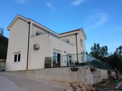 a white house with a balcony on the side of it at Lapčiči View in Budva