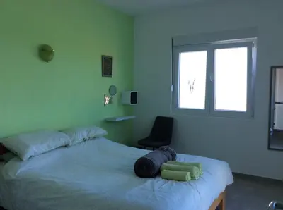 a bedroom with a bed with a chair and a window at Lapčiči View in Budva