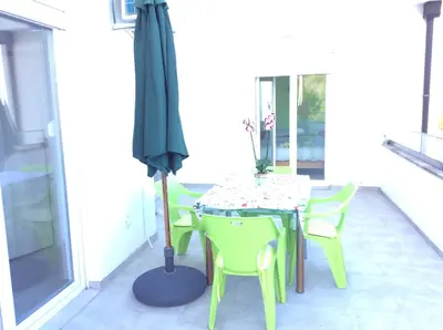 a table and chairs with an umbrella on a patio at Lapčiči View in Budva