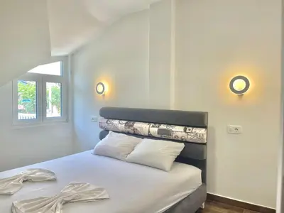 a bedroom with a bed and two lights on the wall at Bucanero Apartments Budva in Budva