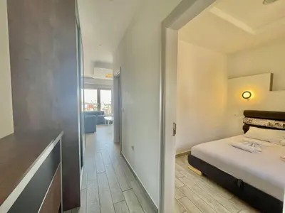 a small bedroom with a bed and a hallway at Bucanero Apartments Budva in Budva