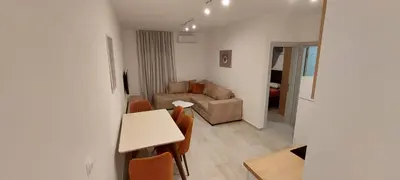 a living room with a table and a couch at Biser Apartmani in Podgorica